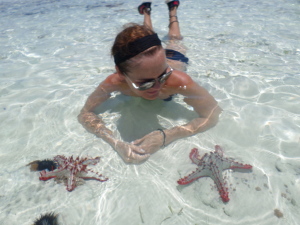 Jurgita looking at two of the manye giant sea-stars that we found in Paje.